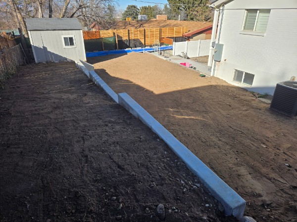 Graded backyard and low retaining border beside a home