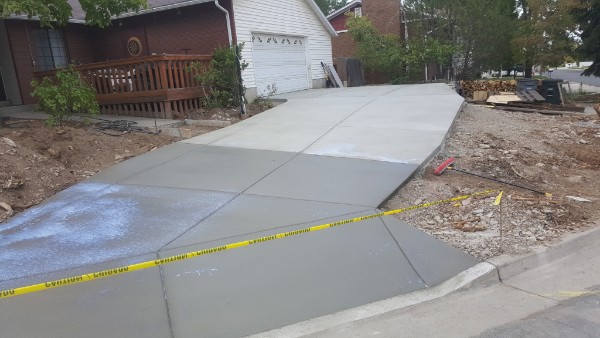 Concrete driveway leading to a white garage with a cupola.