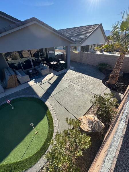 Broad patio/putting-green relationship with palms.