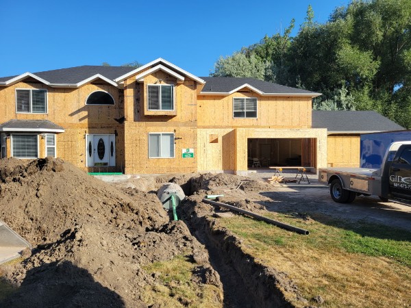 Two-story house with exposed walls, an arched entry window, paired doors and a garage on the right.