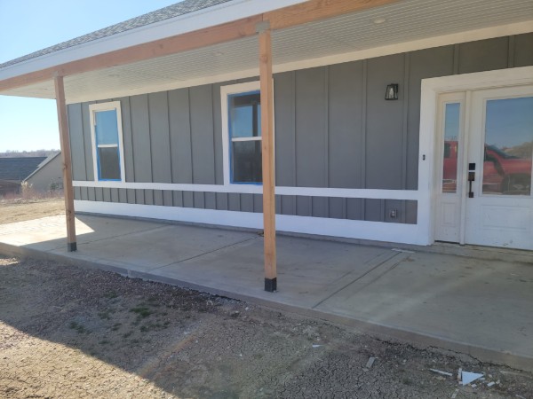 Board-and-batten porch siding with timber support posts.